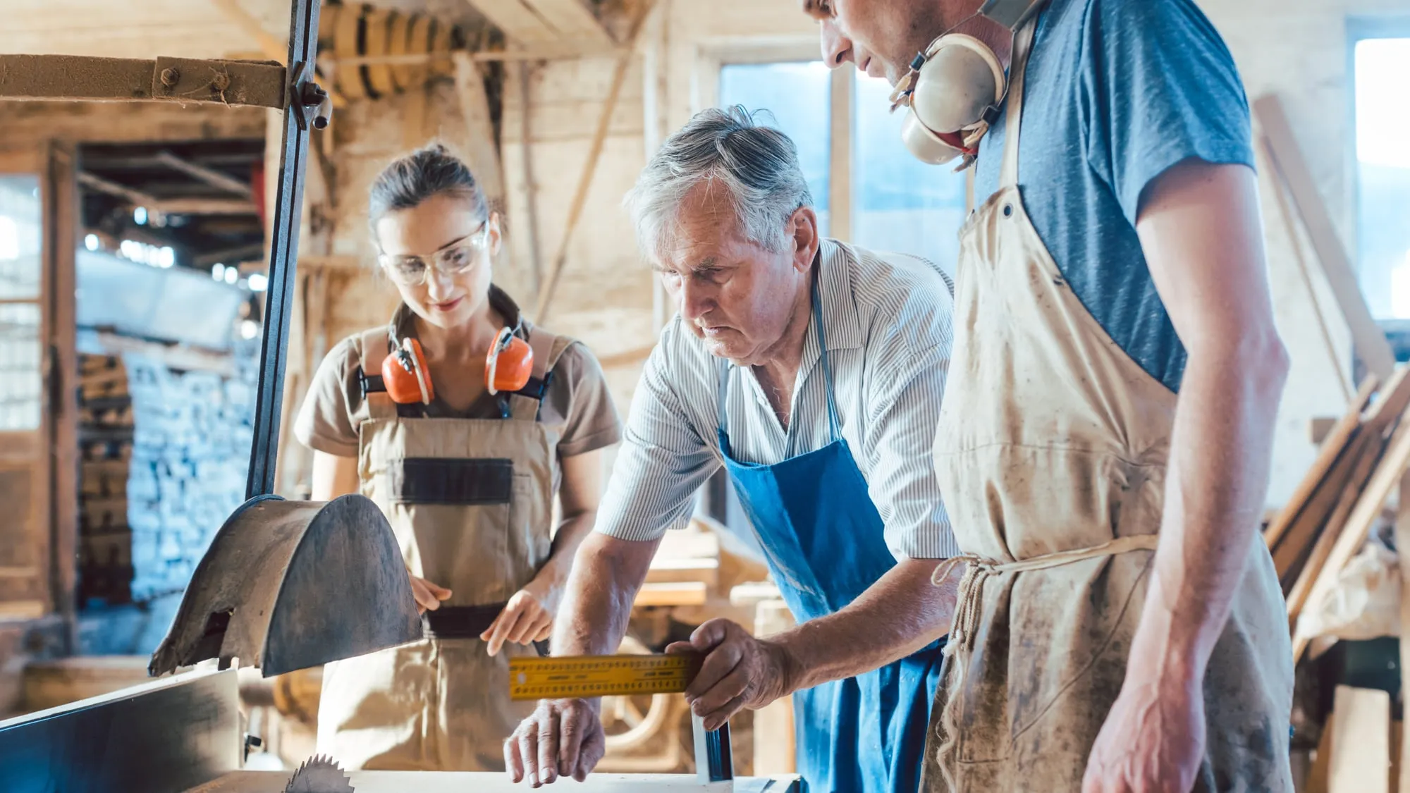 Zwei Generationen arbeiten gemeinsam in einer Handwerkswerkstatt – der Ältere gibt sein Wissen weiter